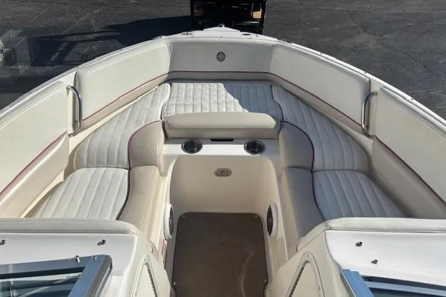 Slide: The Image of 2006 Bryant 219 boat interior with white cushioned seating and cup holders. - 8