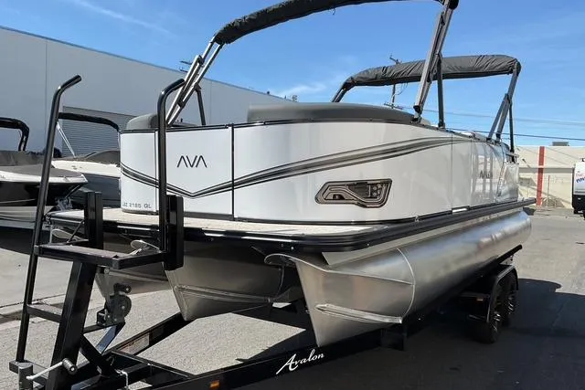 Slide: The Image of 2025 Avalon LSZ Quad Lounge pontoon boat on trailer, outdoor setting. - 2