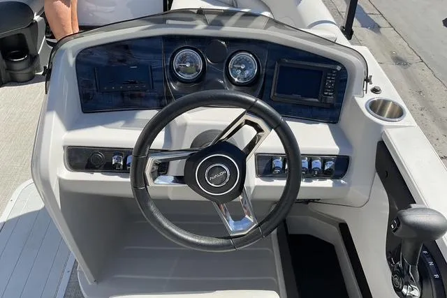 Slide: The Image of 2025 Avalon LSZ Quad Lounge boat dashboard with steering wheel and control panel. - 5
