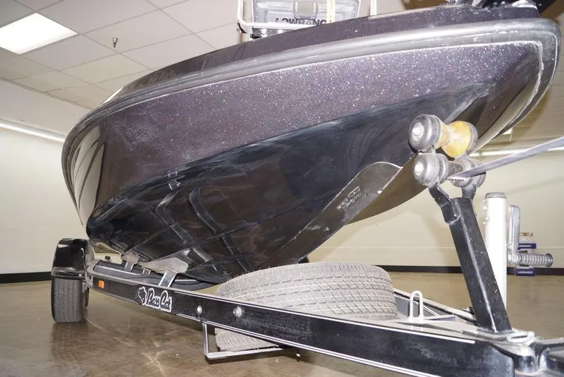 Slide: The Image of 2020 Bass Cat Lynx boat on trailer, showcasing sleek hull design indoors. - 10