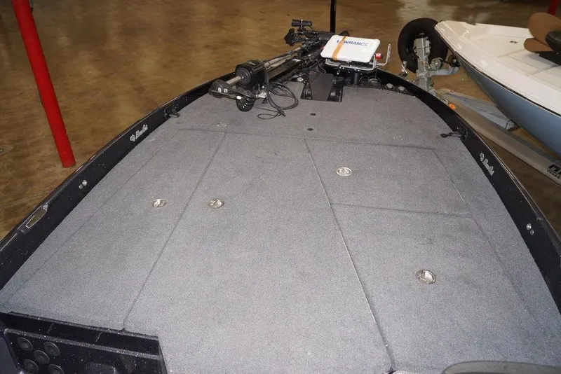 Slide: The Image of 2020 Bass Cat Lynx boat interior with carpeted deck and fishing equipment. - 21