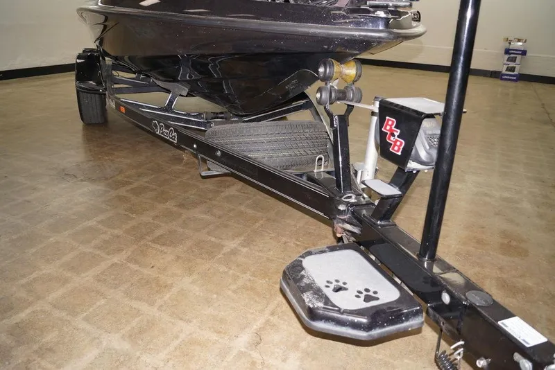 Slide: The Image of 2020 Bass Cat Lynx boat trailer with paw print step, displayed indoors. - 8