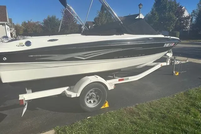 Slide: The Image of 2011 Bayliner 185 boat on trailer, parked outdoors in a residential area. - 1