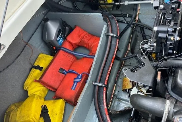 Slide: The Image of Engine compartment of 2011 Bayliner 185 with life jackets and oil container. - 11