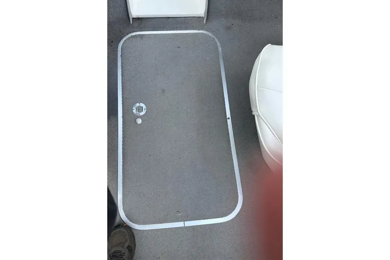 Slide: The Image of 2011 Bayliner 185 boat interior with carpeted floor and storage hatch. - 13