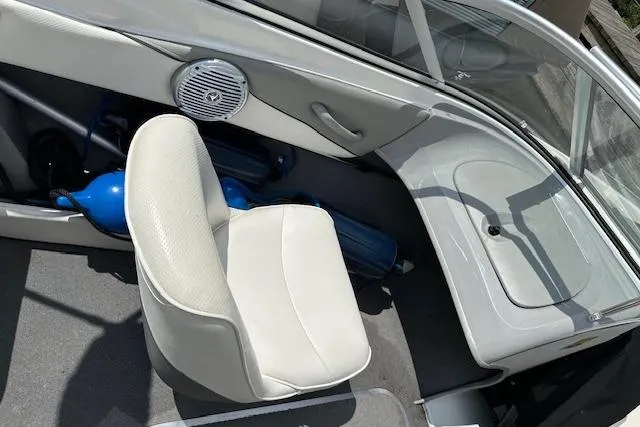 Slide: The Image of Interior of a 2011 Bayliner 185 boat with white seating and blue fenders. - 3