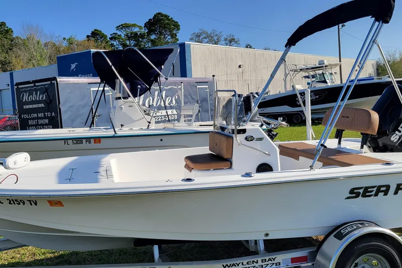 The Image of 2024 Sea Pro 172 Bay boat displayed outdoors with trailer and canopy. - 0