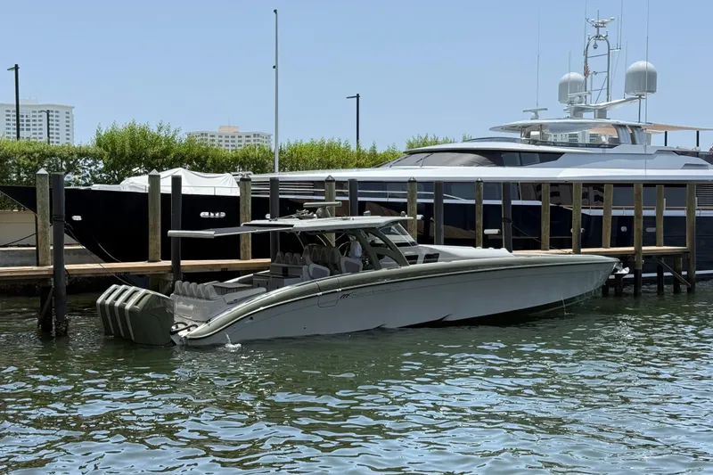 The Image of 2025 Midnight Express 52 Vitesse luxury boat docked beside a yacht in a marina. - 1