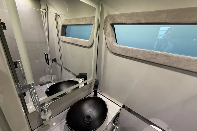 Slide: The Image of Luxurious bathroom interior of 2025 Midnight Express 52 Vitesse yacht, featuring modern sink and window. - 18
