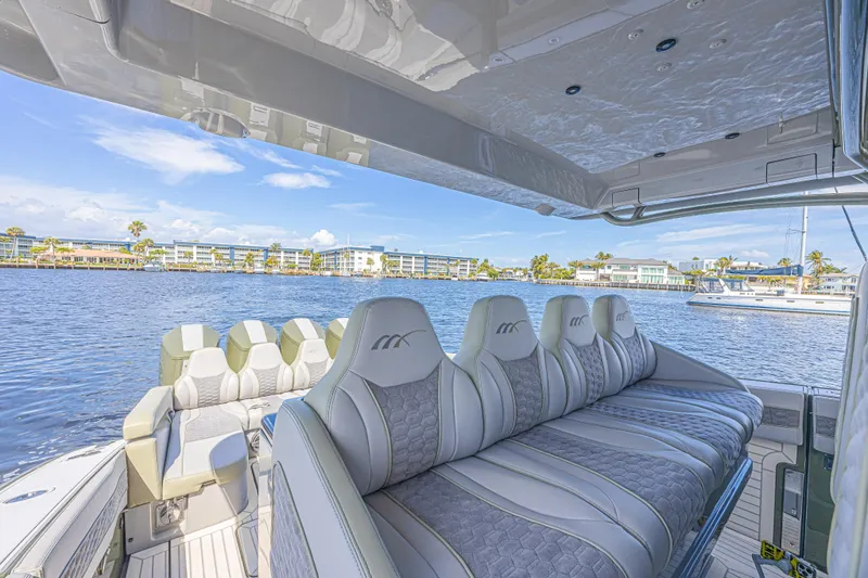 Slide: The Image of Luxurious 2025 Midnight Express 52 Vitesse yacht interior with plush seating on a sunny day. - 25