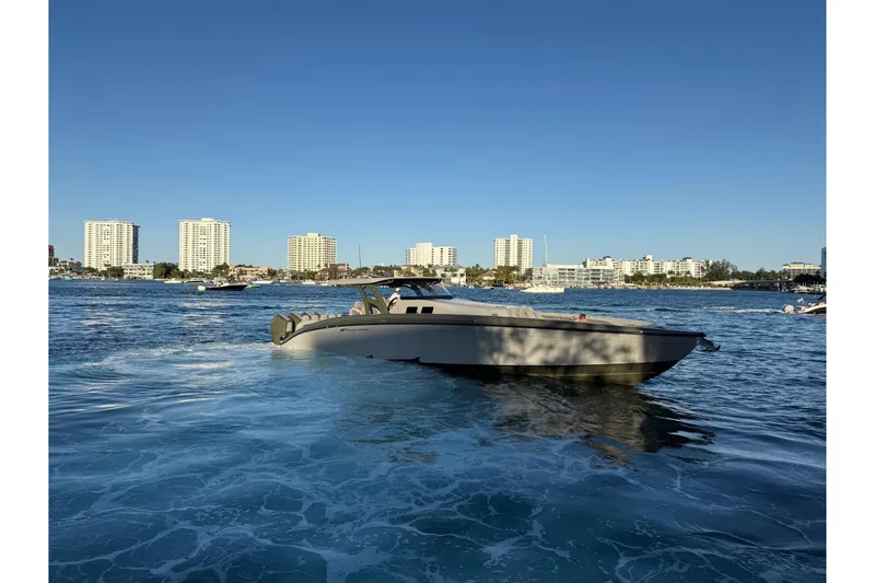 Slide: The Image of 2025 Midnight Express 52 Vitesse yacht cruising in a sunny coastal cityscape. - 3