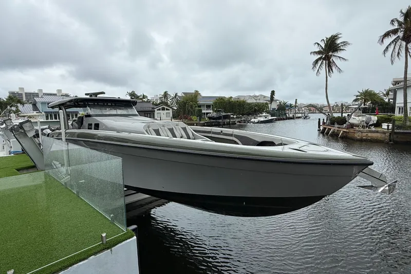 Slide: The Image of 2025 Midnight Express 52 Vitesse luxury boat docked at marina, showcasing sleek design and powerful engines. - 4