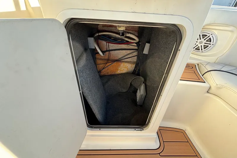 Slide: The Image of 2007 Sea Ray SLX 250 boat interior with white seating and table, parked outdoors. - 18