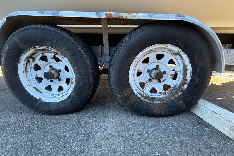 The Image of Trailer wheels of a 2007 Sea Ray SLX 250 boat on pavement. - 3