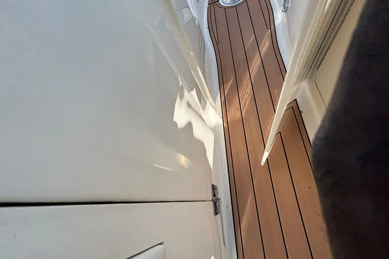 Slide: The Image of 2007 Sea Ray SLX 250 boat dashboard with open storage compartment, clear blue sky background. - 43