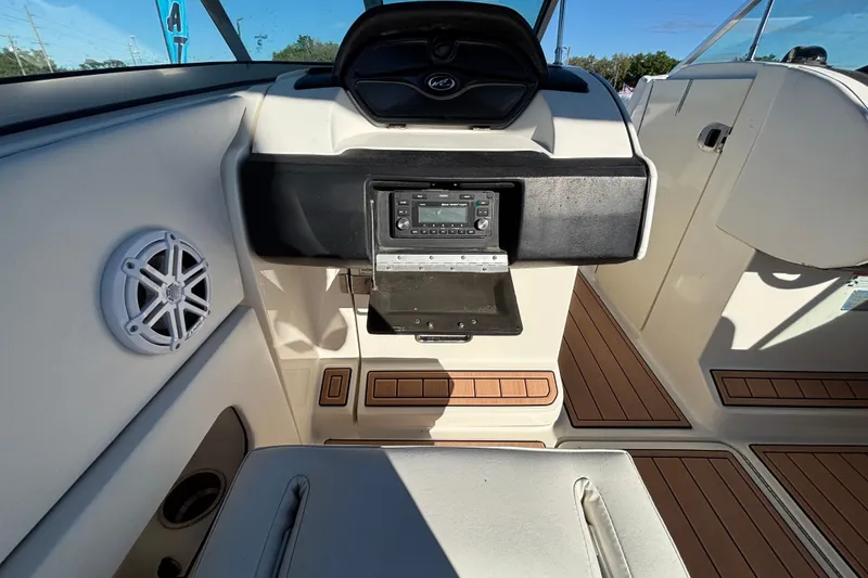 Slide: The Image of 2007 Sea Ray SLX 250 boat interior with white quilted seating and wood accents. - 55