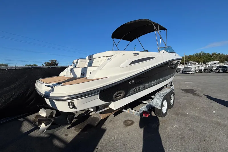 Slide: The Image of 2007 Sea Ray SLX 250 boat with white seating and black canopy, parked outdoors. - 72