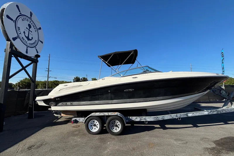 Slide: The Image of 2007 Sea Ray SLX 250 boat with canopy, docked near road, clear sky. - 73