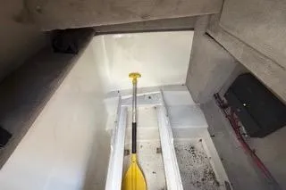 Slide: The Image of Interior storage compartment of a 2007 Sea Ray SLX 250 boat with a yellow paddle. - 77