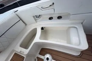 Slide: The Image of 2007 Sea Ray SLX 250 boat interior with storage compartments and teak flooring. - 84