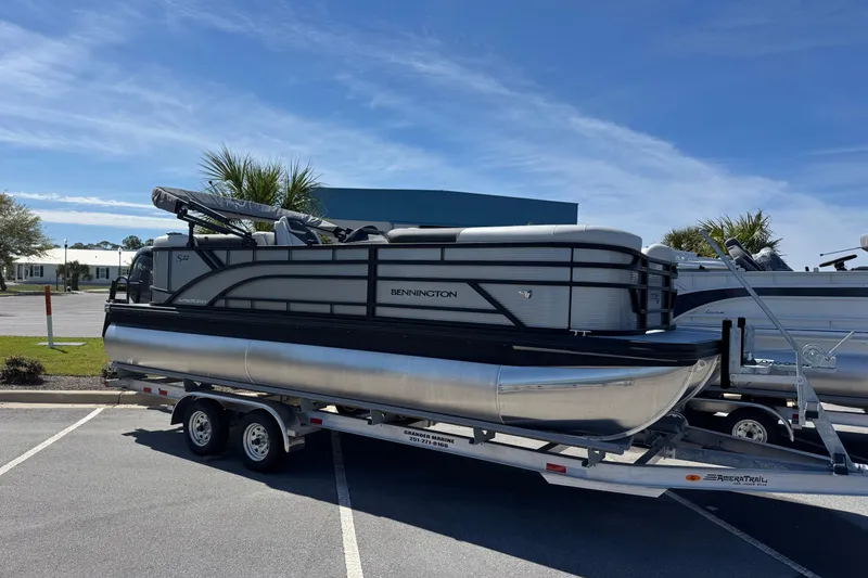 The Image of 2026 Bennington 22 SSR pontoon boat on trailer under clear blue sky. - 1