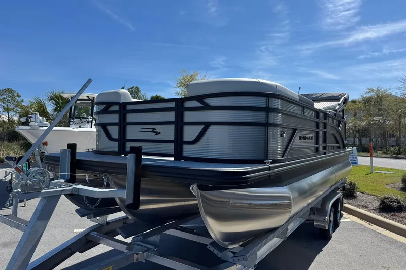 Slide: The Image of 2026 Bennington 22 SSR pontoon boat on trailer under clear blue sky. - 6