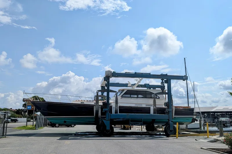 Slide: The Image of 1998 Little Harbor WhisperJet 55 yacht on a lift at a marina under a blue sky. - 48