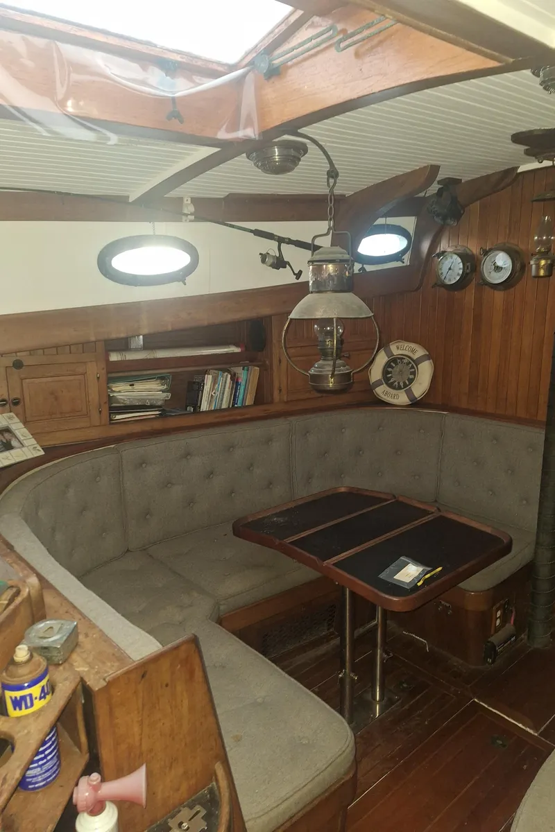Slide: The Image of 1977 Hans Christian 38 sailboat interior with cozy seating, wooden accents, and nautical decor. - 6