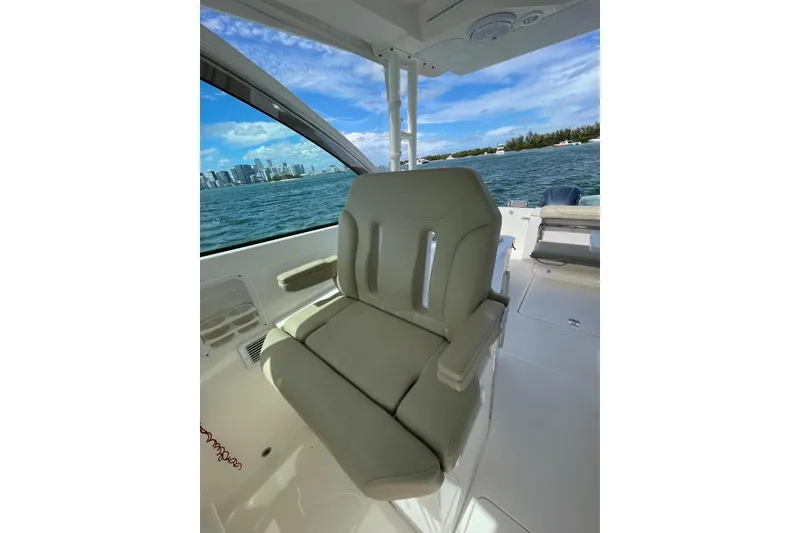 Slide: The Image of 2016 Pursuit DC 325 Dual Console boat interior with comfortable seating and scenic ocean view. - 5