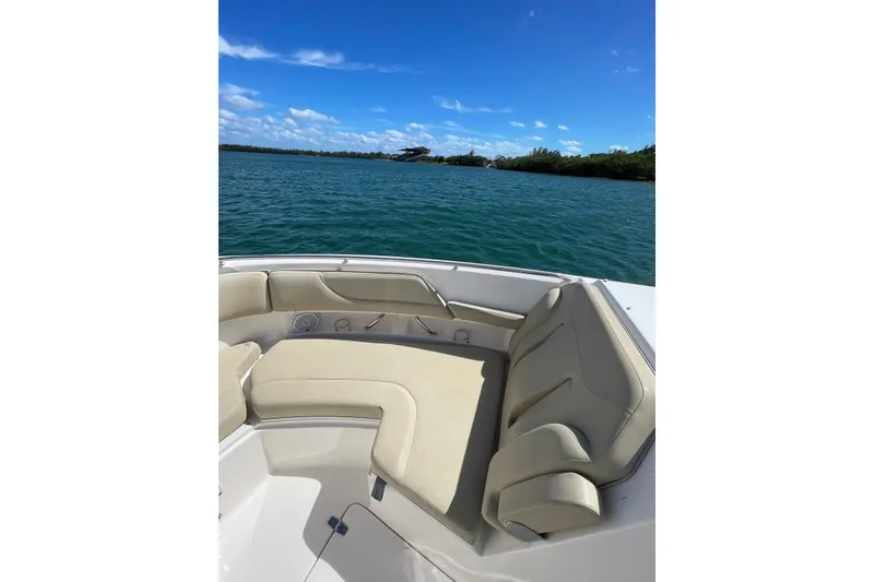 Slide: The Image of 2016 Pursuit DC 325 Dual Console boat with beige seating, on a sunny day by the water. - 9