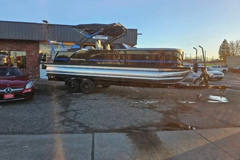 Slide: The Image of 2026 Berkshire 25RFX DC STS SPORT ARCH pontoon boat on trailer, parked outside dealership. - 14