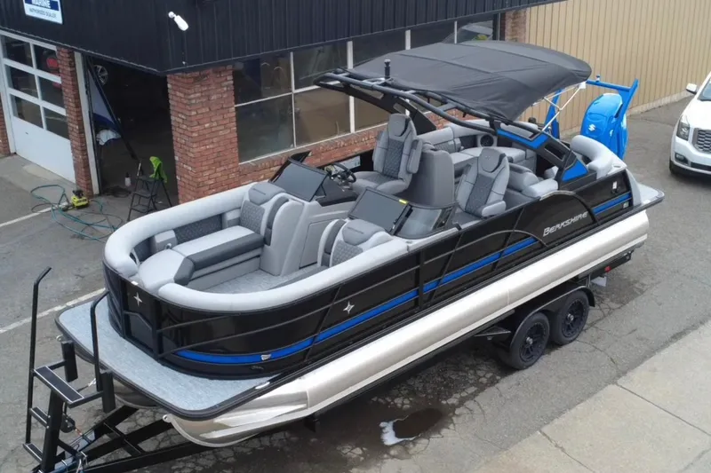 Slide: The Image of 2026 Berkshire 25RFX DC STS SPORT ARCH pontoon boat on trailer, parked outside a building. - 3