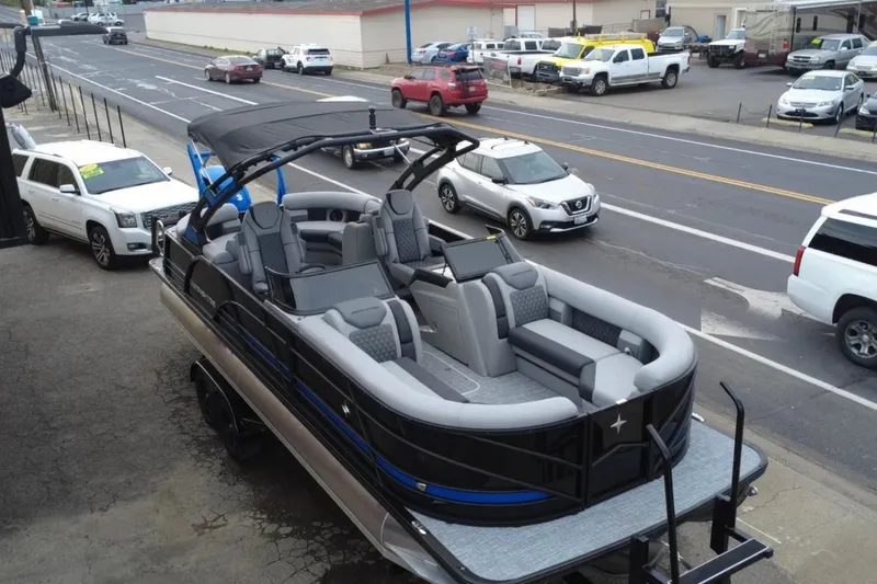 Slide: The Image of 2026 Berkshire 25RFX DC STS SPORT ARCH pontoon boat parked near a busy street. - 5