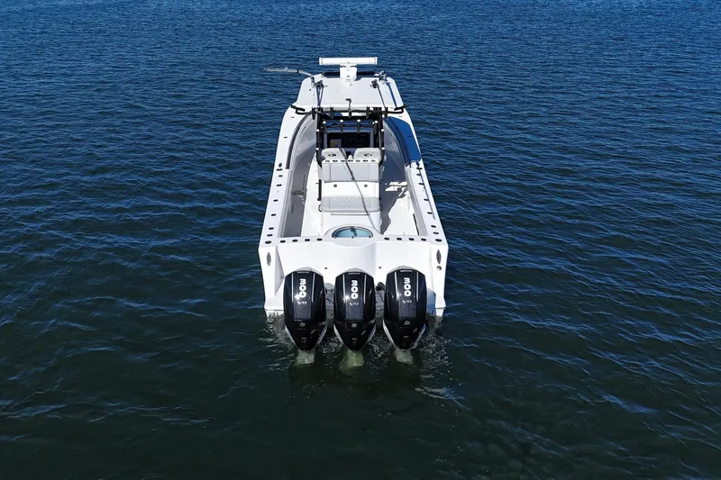 Slide: The Image of 2021 Onslow Bay 33 Tournament boat with triple outboard engines on open water. - 12