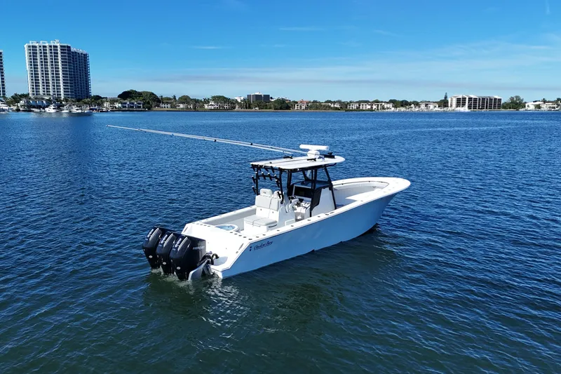 Slide: The Image of 2021 Onslow Bay 33 Tournament boat on calm water with city skyline. - 2