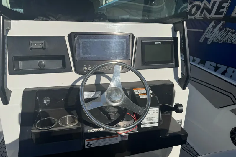 Slide: The Image of 2020 Scarab 255 Open ID boat dashboard with steering wheel and navigation displays. - 14