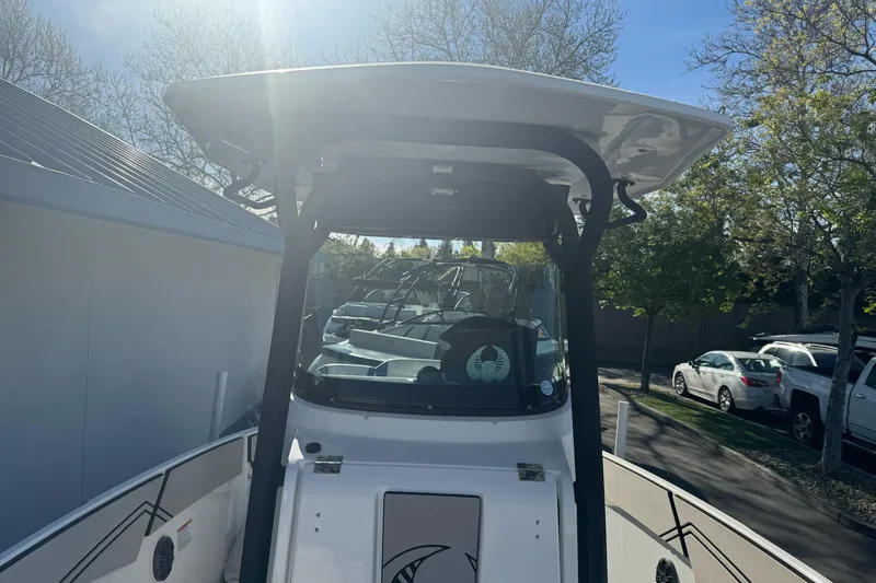 Slide: The Image of 2020 Scarab 255 Open ID boat with T-top, parked outdoors under sunlight. - 29