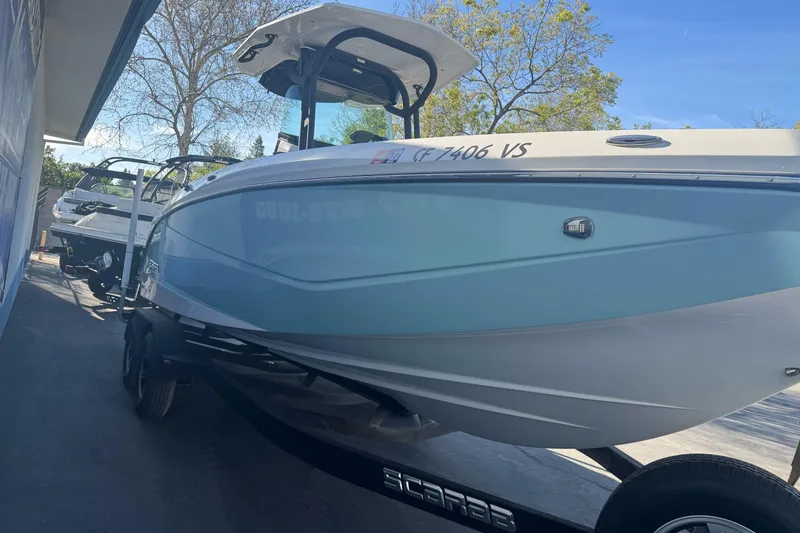 Slide: The Image of 2020 Scarab 255 Open ID boat on trailer, parked outdoors under clear sky. - 5