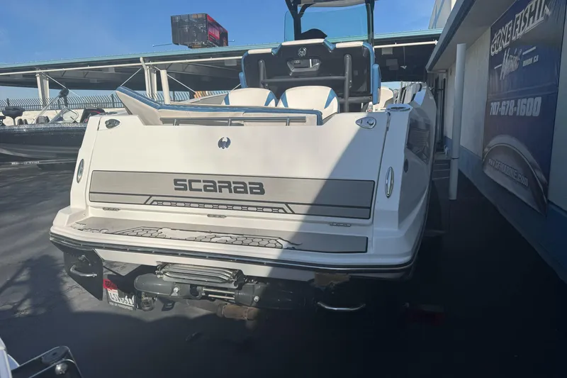 Slide: The Image of 2020 Scarab 255 Open ID boat displayed at a dealership, rear view. - 6