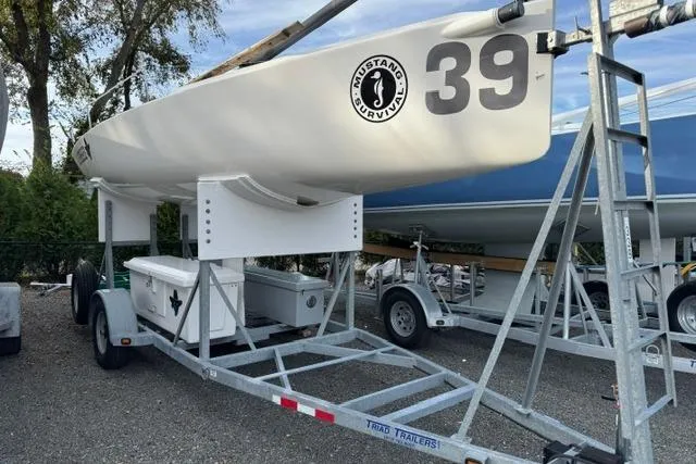 Slide: The Image of 2013 J Boats J/70 sailboat on trailer, marked with number 39, parked outdoors. - 3