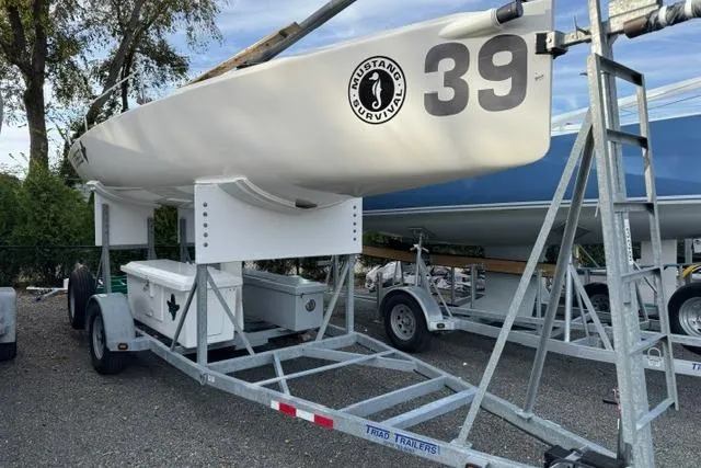 Slide: The Image of 2013 J Boats J/70 sailboat on trailer, marked with number 39, parked outdoors. - 5