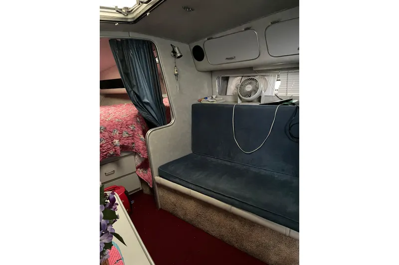 Slide: The Image of Interior of 1987 Chris-Craft 332 Amerosport with seating, storage, and cozy decor. - 13