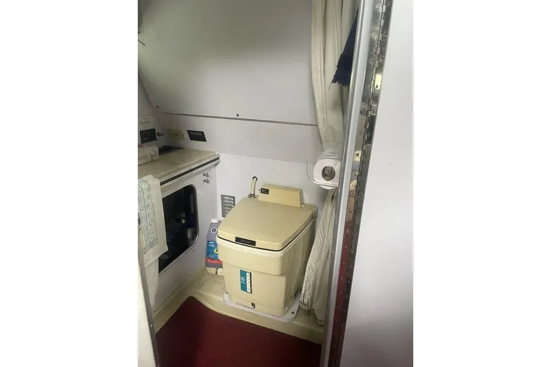 Slide: The Image of 1987 Chris-Craft 332 Amerosport cabin bathroom with compact toilet and storage. - 17