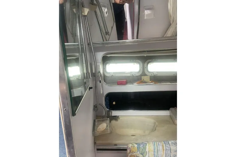 Slide: The Image of 1987 Chris-Craft 332 Amerosport bathroom interior with sink, mirror, and porthole windows. - 20