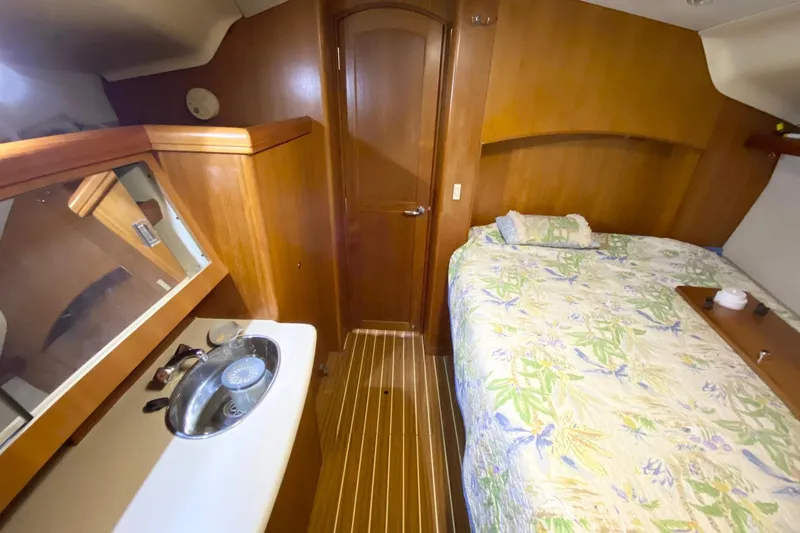 Slide: The Image of Interior of 2006 Hunter 41 Deck Salon with bed, sink, and wooden cabinetry. - 15