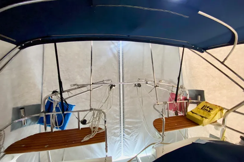 Slide: The Image of Interior view of 2006 Hunter 41 Deck Salon sailboat with blue canopy and wooden seating. - 19