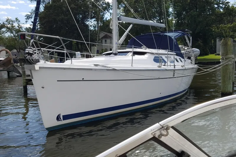 Slide: The Image of 2006 Hunter 41 Deck Salon sailboat docked in a serene marina setting. - 2