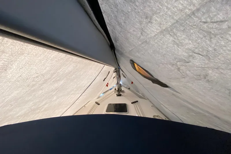 Slide: The Image of 2006 Hunter 41 Deck Salon sailboat under a protective cover, showcasing mast and deck details. - 20