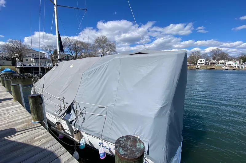Slide: The Image of Covered 2006 Hunter 41 Deck Salon sailboat docked by the water under a blue sky. - 22