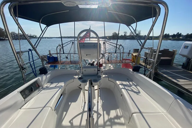 Slide: The Image of 2006 Hunter 41 Deck Salon sailboat cockpit with helm, docked on a sunny day. - 24